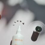 Kosmetyki na tle z cieniami, podkreślone różne konsystencje produktów